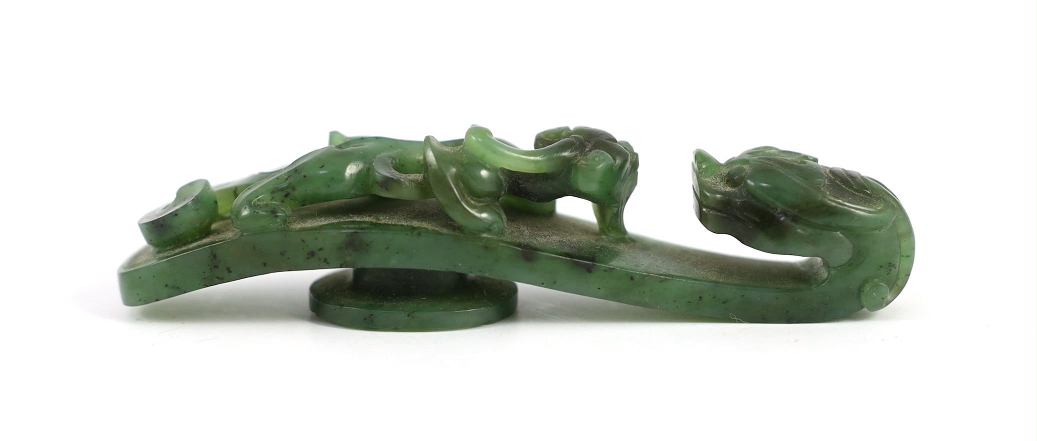 A Chinese bright spinach green jade ‘dragon’ belt hook, 18th/19th century, 9.5cm long